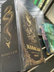 The limited edition hardcover novel Manacled (printed on three sides) collec