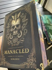 The limited edition hardcover novel Manacled (printed on three sides) collec